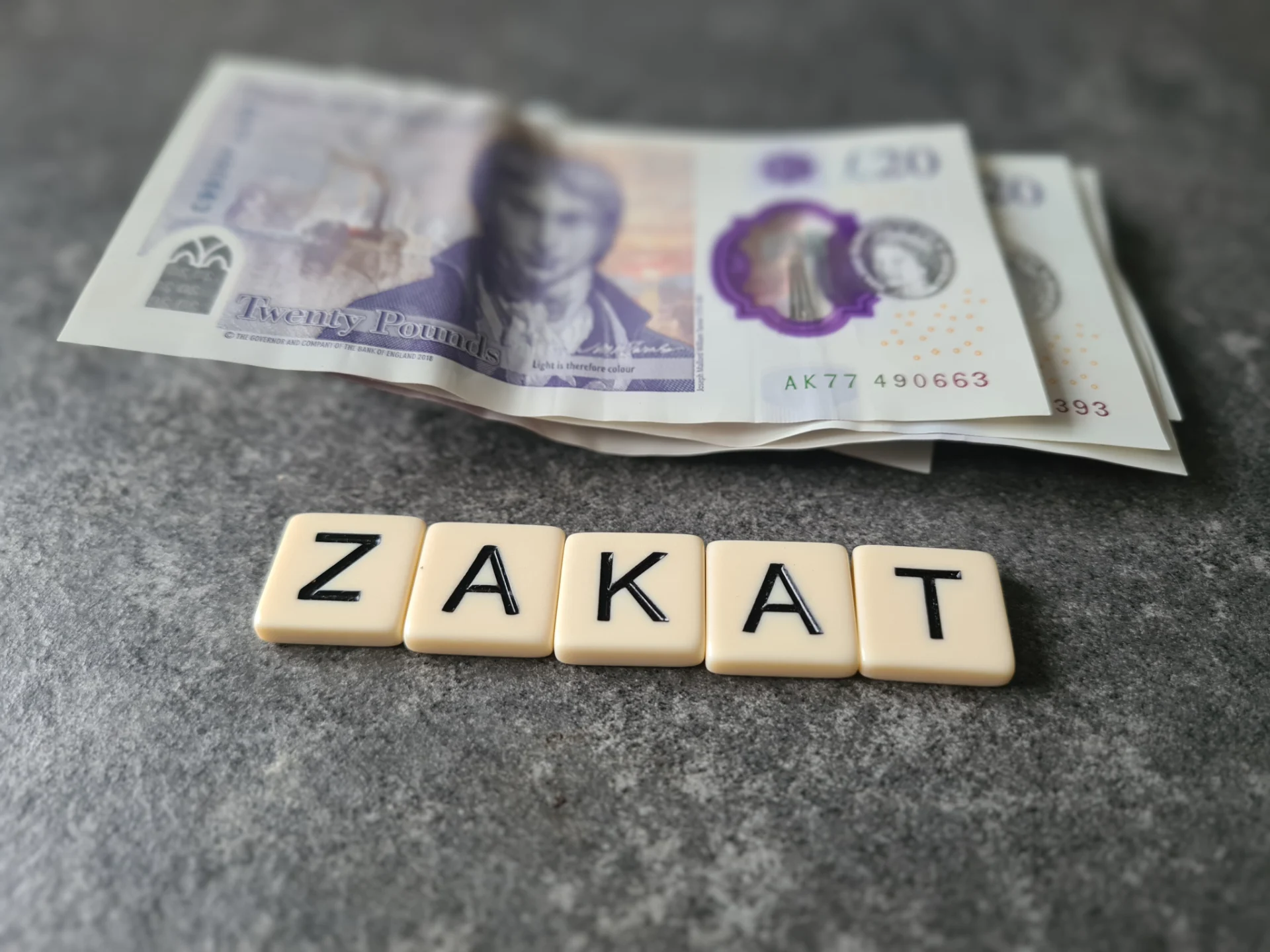 Zakat tiles with British currency on table.