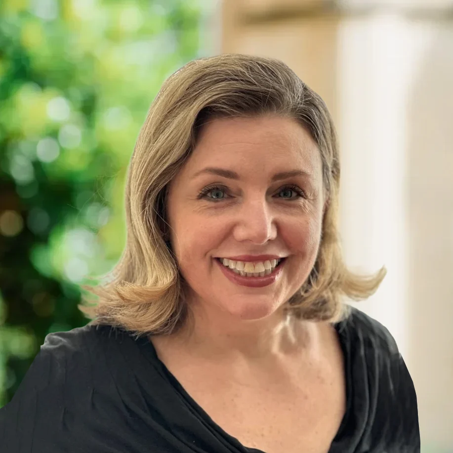 Smiling person with short hair outdoors