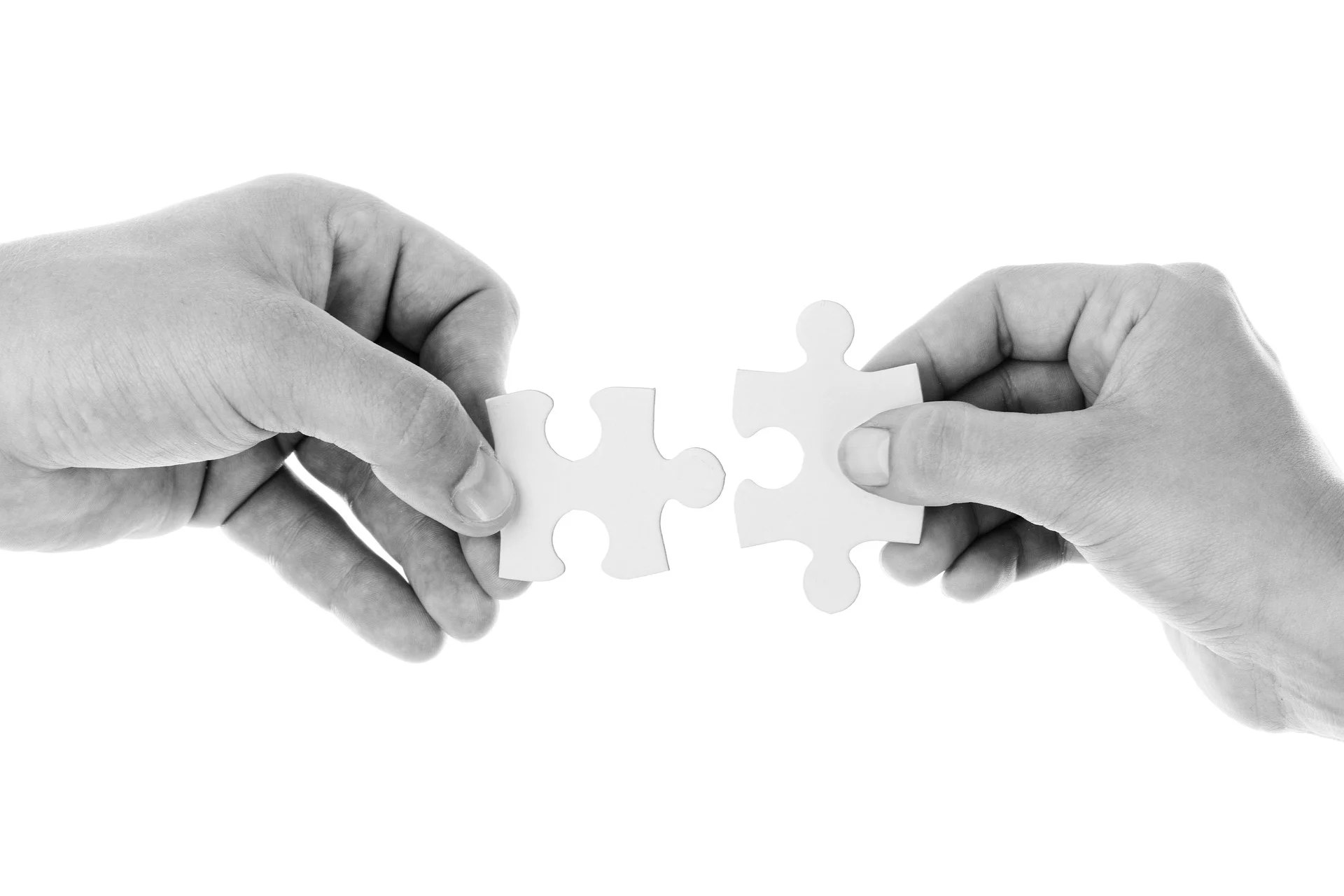 Hands connecting jigsaw puzzle pieces