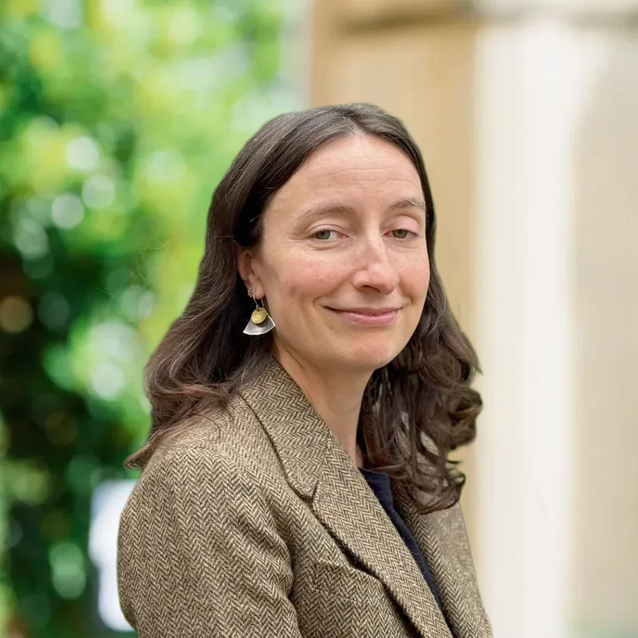 Smiling woman in a tweed blazer outdoors