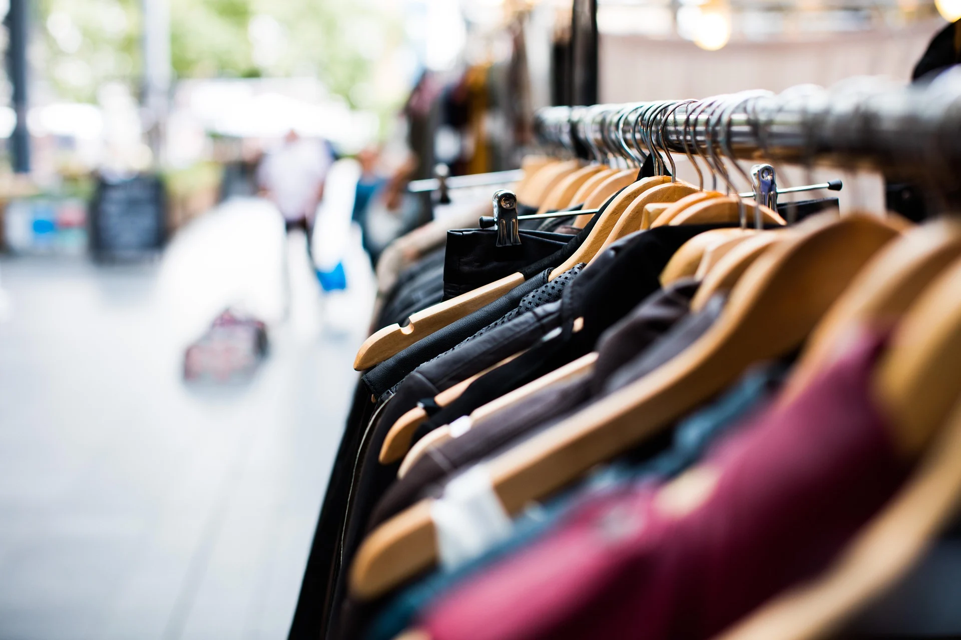 Clothing rack with garments on wooden hangers