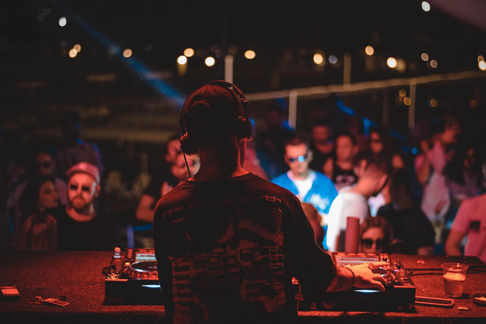 DJ performs for a crowded nightclub audience